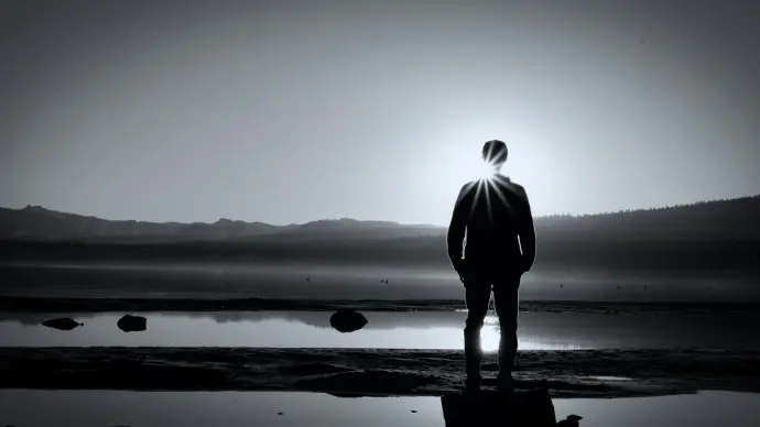 a man standing in front of a body of water